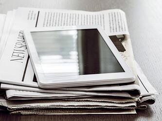 Newspapers and a tablet computer